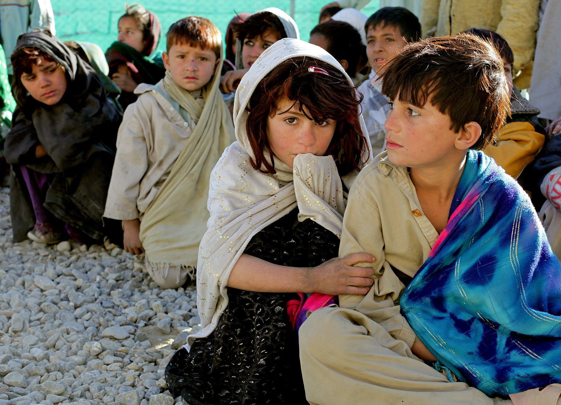 This photo displays a group of children in Afghanistan waiting for a food distribution delivered by a charity as part of their effort to meet the Sustainable Development Goals