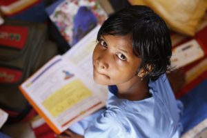 Girl reading textbook at school