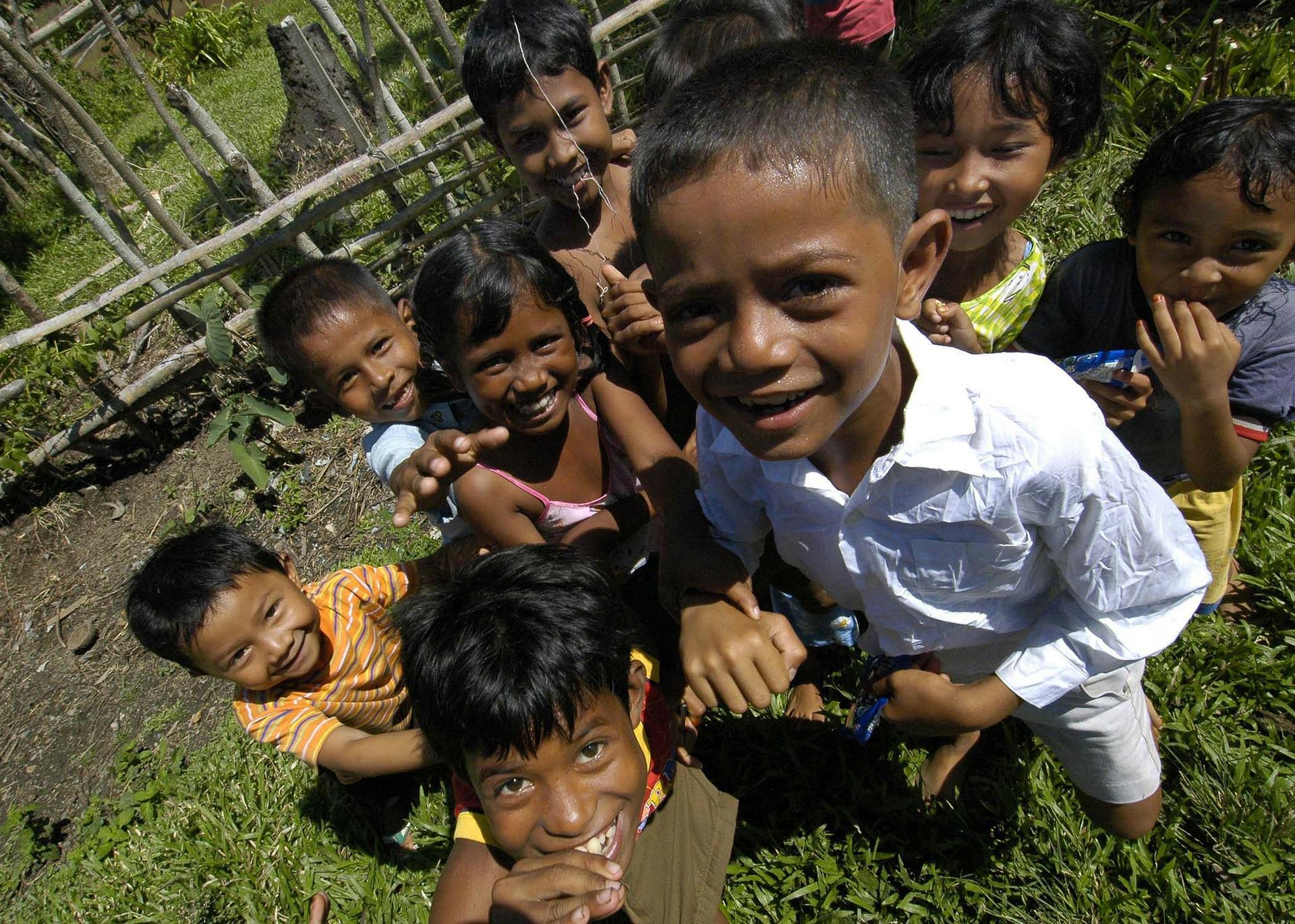 8 young children smiling up to the camera in Sumatra